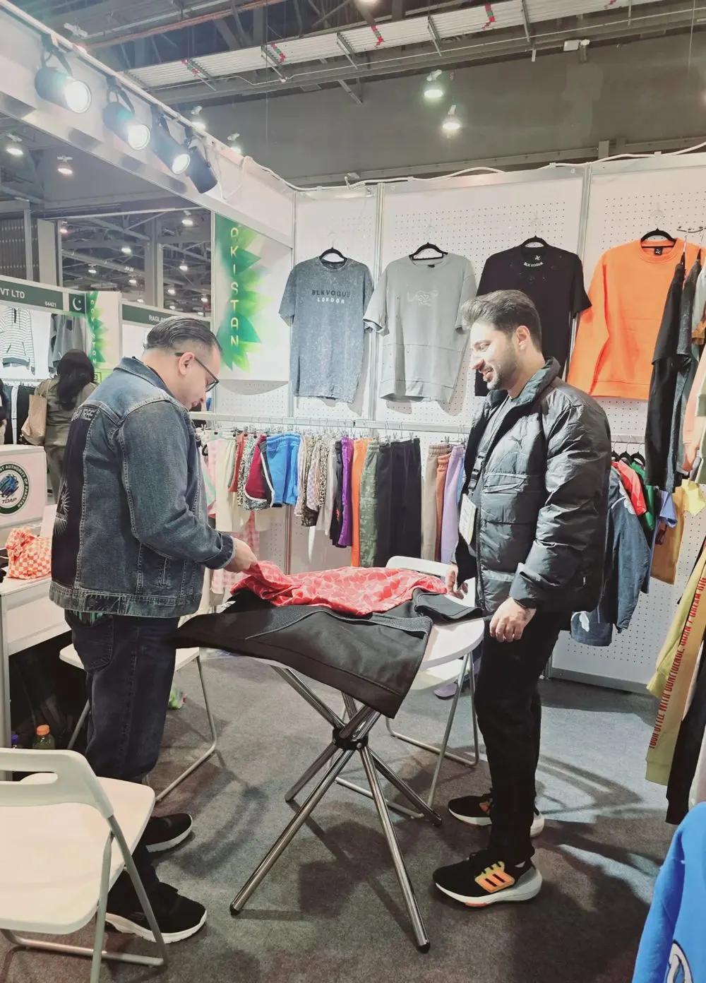 ZK International team with a buyer at a garment exhibition stand